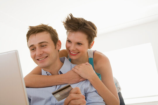 Young Couple with Credit Card and using Computer