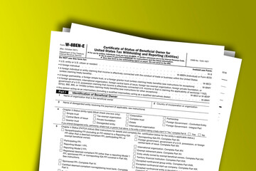 Form W-8BEN-E documentation published IRS USA 44540. American tax document on colored