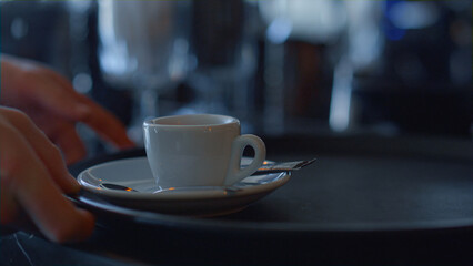 Barista hands giving fresh coffee cup to waiter closeup. Person made drink