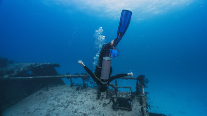 diver playing with the non gravity underwater near a shipwreck