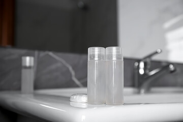 Bottles of shower gel on sink in bathroom. Space for text