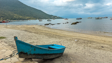 Fototapeta na wymiar Small blue boat anchored at the edge of the beach.