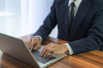 People using computer Side view of male hands typing on laptop keyboard