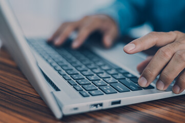 Fototapeta na wymiar People using computer Side view of male hands typing on laptop keyboard