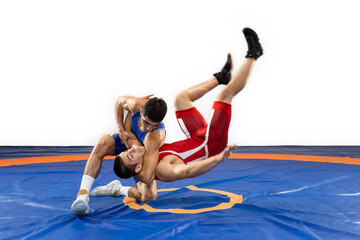 The concept of fair wrestling. Two greco-roman  wrestlers in red and blue uniform wrestling   on a...