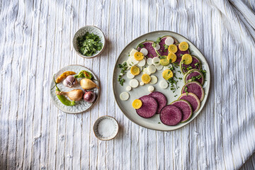 Brightly colored radishes and other fall vetables on a plate - healthy, vegan food ingredients