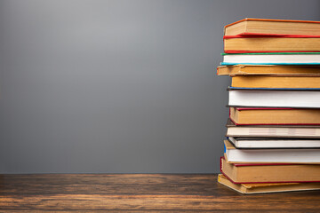 A stack of books in a colored cover and a book with old pages on a gray background. Education learning concept