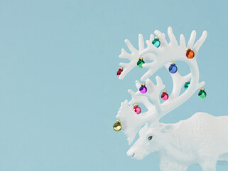 Creative Christmas concept made with white Christmas reindeer with antlers with christmas baubles...