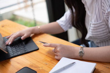 Young woman with credit card shopping over portable tablet and smartphone while sitting at cafe....