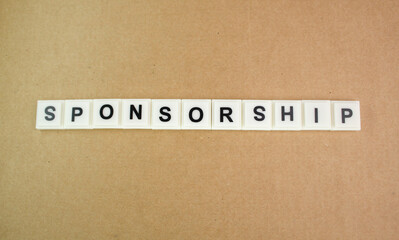 magnifying glass and letters of the alphabet with the word sponsorship. sponsorship concept