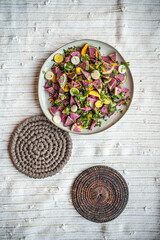 flatlay food photo of colorful fresh salad on yellow and white textile mat