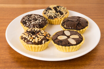 Mini tart with brownie filling. Crispy on the outside, soft on the inside, combined with various toppings such as peanuts, choco chips, cheese and almonds. Perfect for serving with coffee and tea