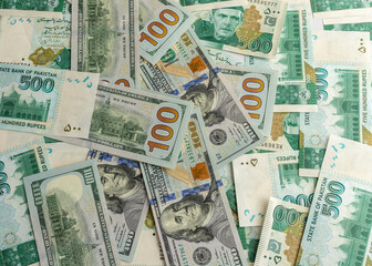 Fototapeta na wymiar US hundred dollar bills with Pakistan five hundred rupees bank notes