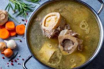 Foto op Plexiglas Boiled bone and broth. Homemade beef bone broth is cooked in a pot on. Bones contain collagen, which provides the body with amino acids, which are the building blocks of proteins. © Esin Deniz