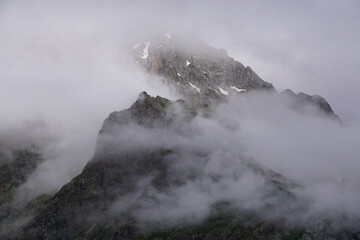 fog over the mountain by the  snowy peak in the southern Alps, France