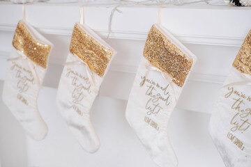 White beautiful Christmas socks hanging on fireplace