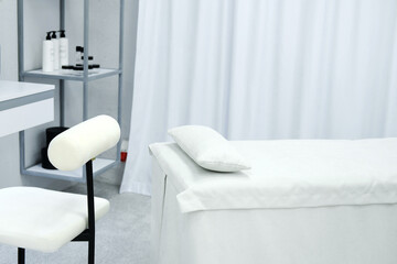 The interior of the office of a beauty specialist. A white chair stands next to the couch