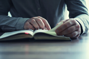 Read book. A man sits and reads religion literature. Textbooks to study.