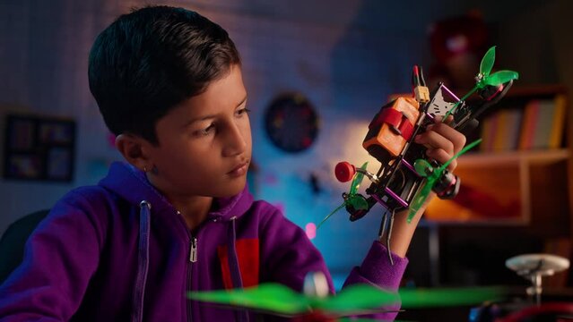 young teenager kid thinking about drone flight at home during night - concept of brainstorm, nerd and curiosity
