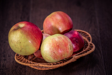 Still life of fresh peaches and apples on a dark background.