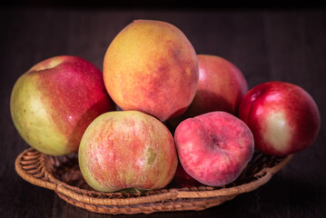 Fototapeta na wymiar Still life of fresh peaches and apples on a dark background.