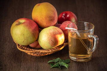 Still life of fresh peaches and apples on a dark background.