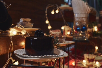 Pastel de chocolate con fondo de adornos navideños, luces cálidas y postres variados