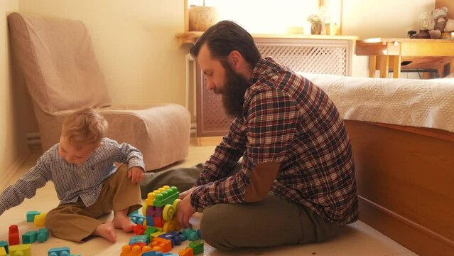the father is playing with the boy in the constructor. father plays with his son in the constructor