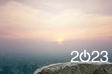 Fototapeta premium 2023 start up business flat icon on rock mountain over aerial view of cityscape at sunset, vintage style, Happy new year 2023 success concept