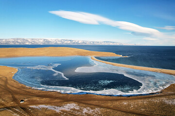 Winter landscape from the air. Frozen Lake Khankhoy on the island of Olkhon and unfrozen Lake Baikal in December.