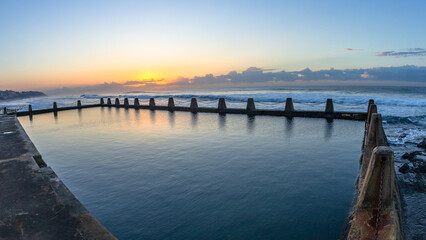 Fototapeta na wymiar Beach Tidal Swimming Pool Calm Smooth Sea Water With Horizon Ocean Sunrise A Scenic Landscape.