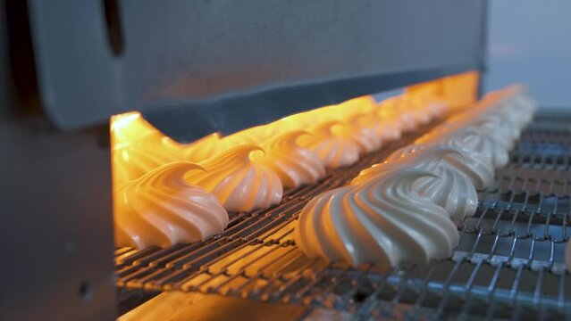 Automatic feeding of marshmallows on a conveyor to an infrared oven for drying. Confectionery factory.
