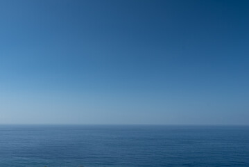 Blue ocean or sea background with blank space. Blue sky above calm water