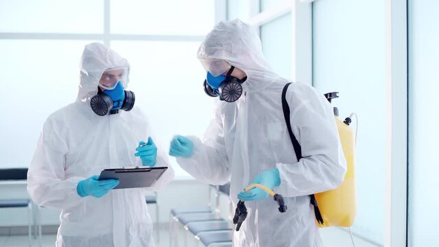 disinfectors discussing the treatment plan of a public building.