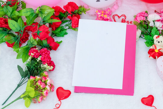 White blank A5 paper on the to of a folded pink file folder surrounded by valentine themed decorations