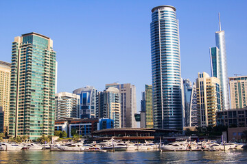 Obraz na płótnie Canvas photo background view of the yacht club in Dubai Marina and the water of the bay, and residential buildings around, Dubai, United Arab Emirates
