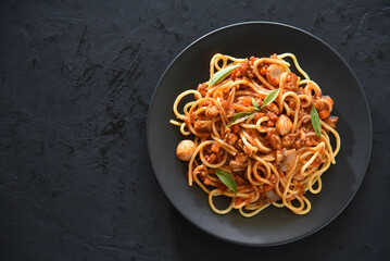Spaghetti plate on black stone background and space for text.