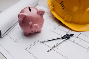 Savings and costs. Yellow safety helmet and pink piggy bank with drawings