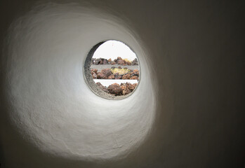Naklejka premium closeup of small circular window piercing the thick walls of a wall