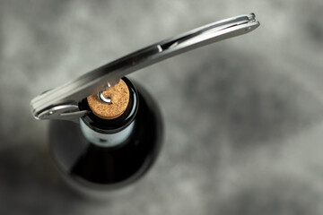 Bottle, corkscrew and cork on a black background. Selective focus. - obrazy, fototapety, plakaty