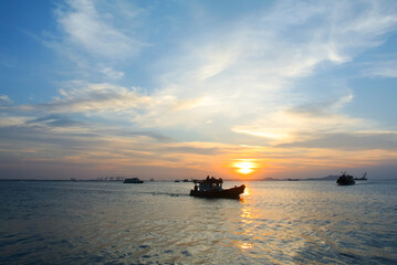 Silhouette of ferry at sea with sunset sky background