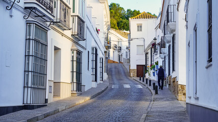 Fototapeta na wymiar Man walking through the narrow streets of the white and picturesque village of Medina Sidonia, Cadiz.