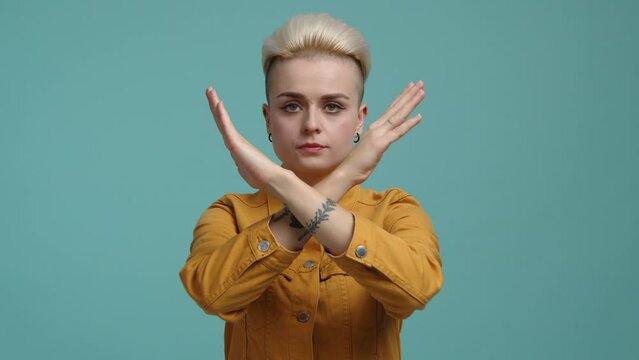 Emotional woman with blonde hair asking to stop. Close-up view of a confident girl with short haircut crossing her arms. High quality 4k footage