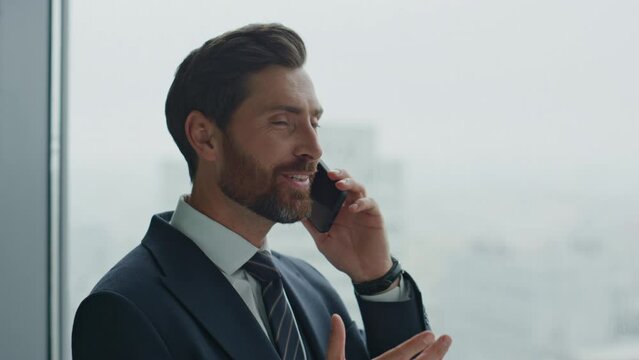 Entrepreneur speaking mobile phone near office window close up. Business talk.