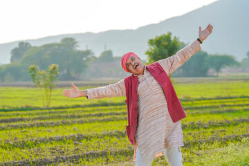 Indian farmer giving expression at agriculture field.