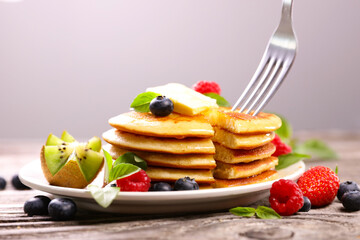 stack of pancakes with fresh fruits and fork