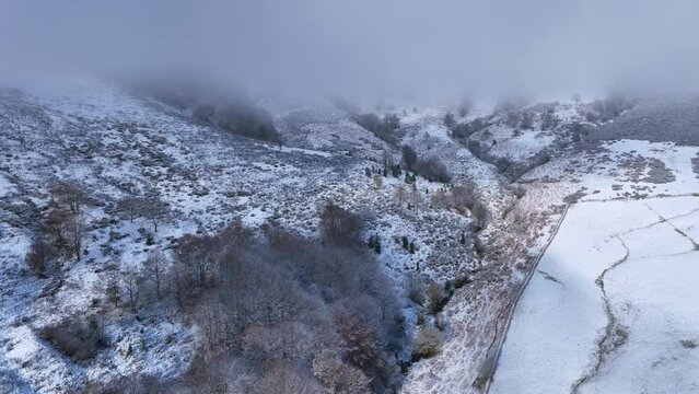 Snowy landscape of cabins and meadows in Puerto de los Tornos, between Cantabria and Burgos. Aerial view from a drone. Castile and Leon, Spain, Europe