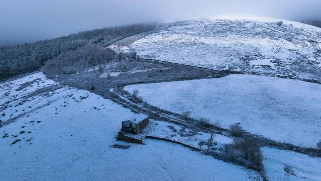 Snowy landscape of cabins and meadows in Puerto de los Tornos, between Cantabria and Burgos. Aerial view from a drone. Castile and Leon, Spain, Europe