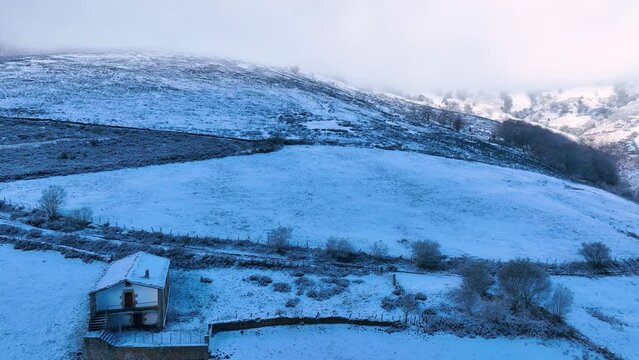 Snowy landscape of cabins and meadows in Puerto de los Tornos, between Cantabria and Burgos. Aerial view from a drone. Castile and Leon, Spain, Europe