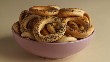 Bowl with delicious ring shaped Sushki (dry bagels) on beige background, closeup